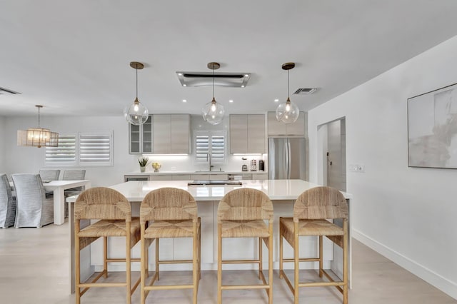 530 NW 14th St, Delray Beach, FL 33444 - kitchen featuring freestanding refrigerator, a sink, light countertops, a kitchen breakfast bar, and a center island