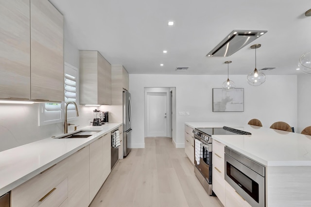 530 NW 14th St, Delray Beach, FL 33444 - kitchen with modern cabinets, stainless steel appliances, a sink, light countertops, and light wood-style floors