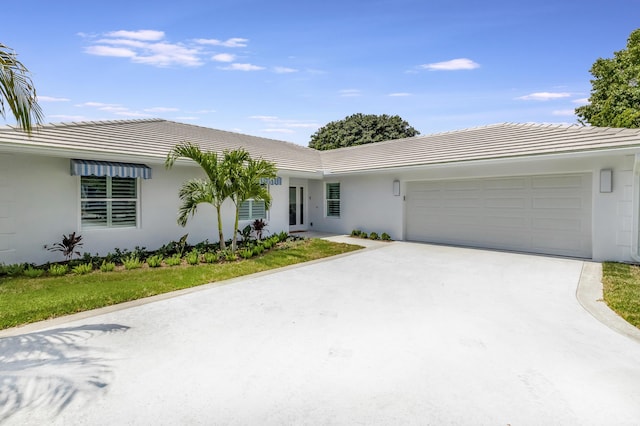 530 NW 14th St, Delray Beach, FL 33444 - view of front of home featuring a garage, concrete driveway, stucco siding, and a tiled roof