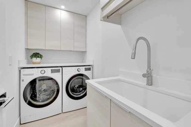530 NW 14th St, Delray Beach, FL 33444 - laundry room with washing machine and dryer, cabinet space, and light wood-style floors