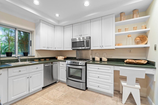 kitchen with sink, appliances with stainless steel finishes, white cabinets, and light tile patterned flooring