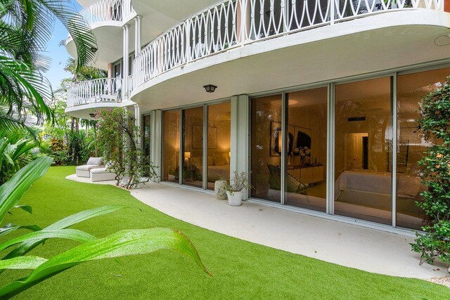 rear view of property featuring a balcony and a patio area