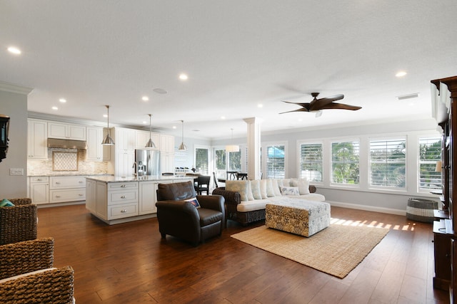 living room with a healthy amount of sunlight, ceiling fan, hardwood / wood-style floors, and crown molding