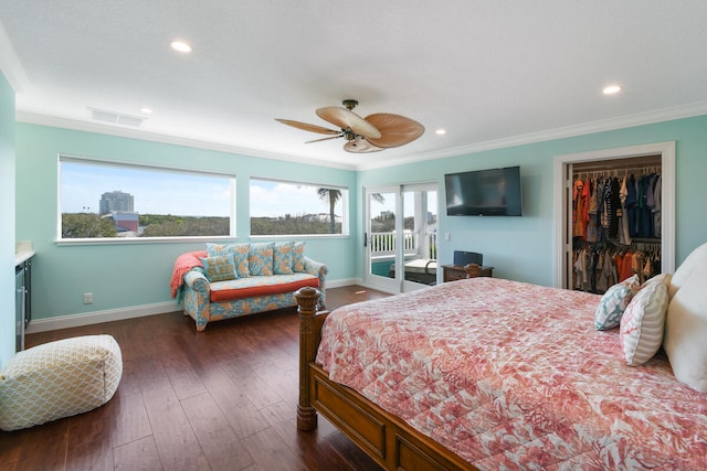 bedroom featuring a closet, a spacious closet, ceiling fan, crown molding, and dark wood-type flooring