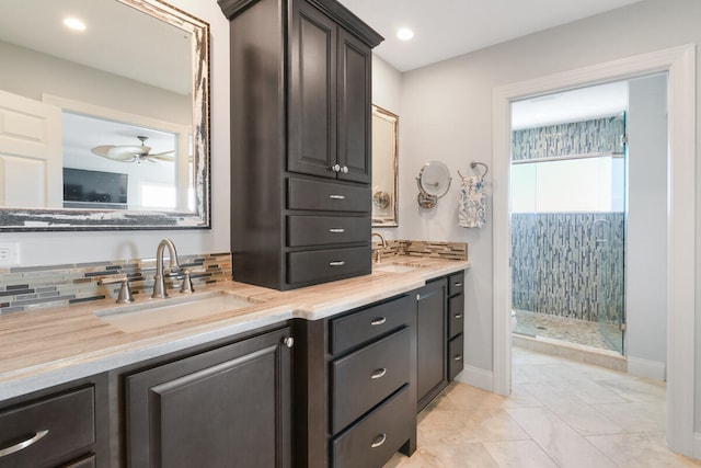 bathroom featuring tile patterned flooring, tiled shower, decorative backsplash, vanity, and ceiling fan