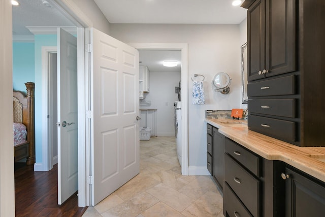 bathroom with washer / dryer, ornamental molding, and tile patterned floors