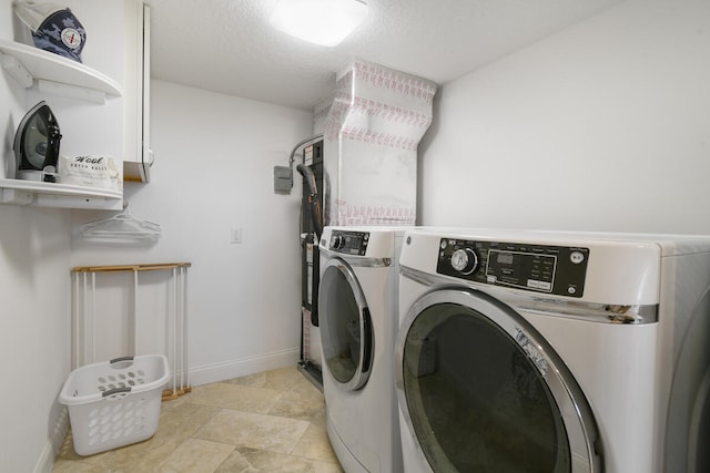 clothes washing area featuring light tile patterned flooring and washing machine and clothes dryer