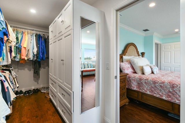 bedroom with crown molding, dark wood-type flooring, and a closet