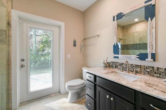 bathroom with vanity, toilet, a wealth of natural light, and backsplash