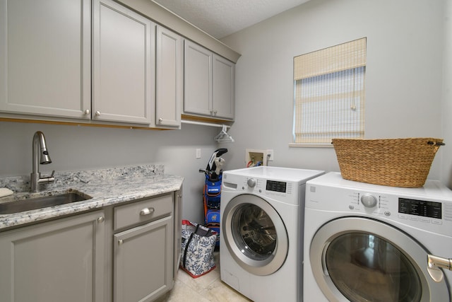 washroom with cabinets, independent washer and dryer, light tile patterned floors, and sink