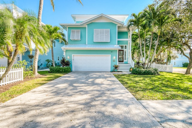 raised beach house featuring a garage and a front yard