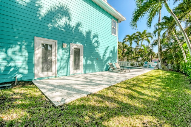 back of property with a yard and a patio area