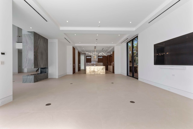 unfurnished living room featuring a raised ceiling