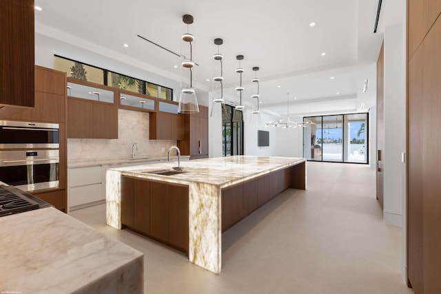 kitchen featuring a large island, a healthy amount of sunlight, sink, and pendant lighting