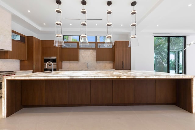 kitchen with appliances with stainless steel finishes, decorative light fixtures, and backsplash