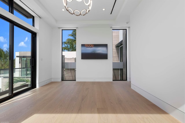 empty room with a chandelier and wood-type flooring