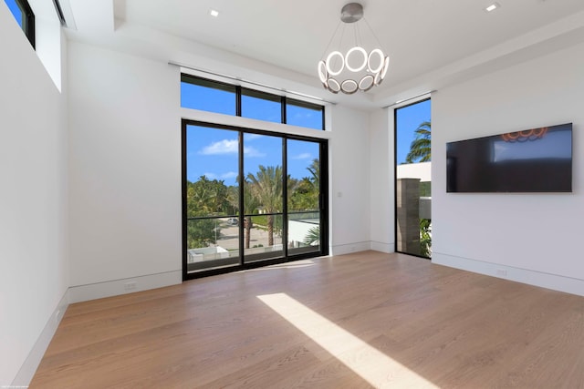 unfurnished living room featuring light hardwood / wood-style floors and an inviting chandelier