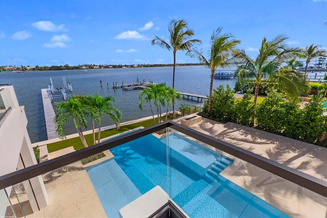 view of swimming pool featuring a patio area, a water view, and a boat dock