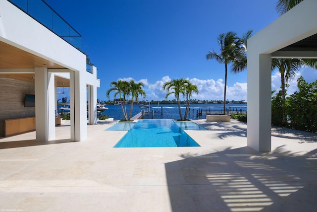 view of pool with a water view and a patio area