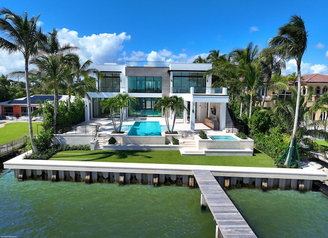 rear view of property with a water view, a patio, and a pool with hot tub