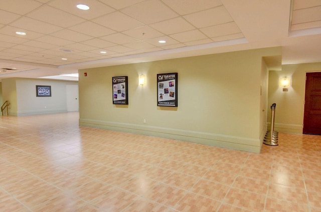 basement with light tile patterned floors and a paneled ceiling