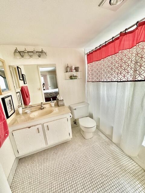 bathroom with a shower with curtain, vanity, and toilet