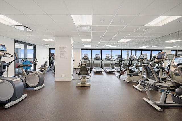 exercise room featuring a drop ceiling and floor to ceiling windows