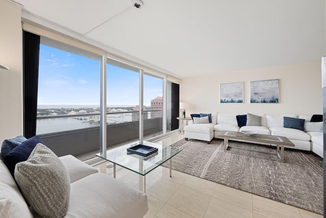 tiled living room featuring floor to ceiling windows and a water view