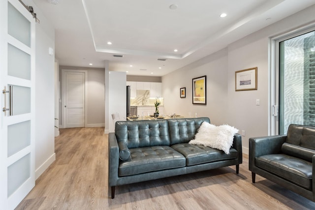 41 SW Seminole St Unit 404, Stuart, FL 34994 - living room with light wood-style floors, built in features, recessed lighting, baseboards, and a tray ceiling