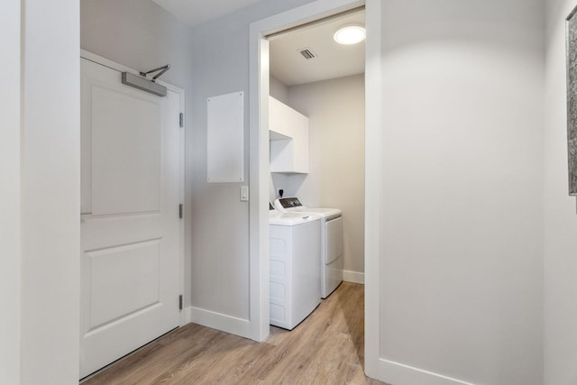 washroom with separate washer and dryer and light hardwood / wood-style flooring