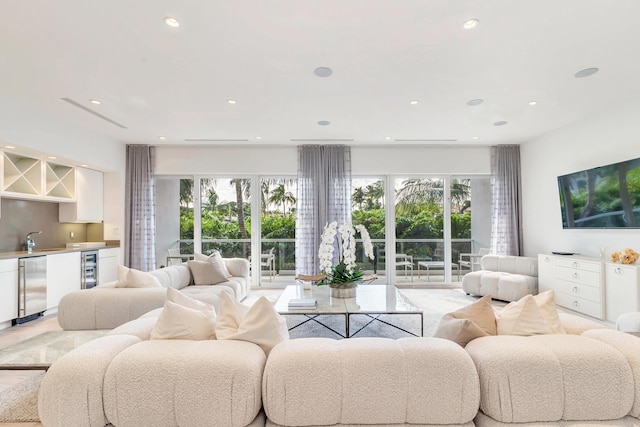 living room featuring beverage cooler, a healthy amount of sunlight, recessed lighting, and wet bar