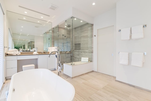 full bathroom with a stall shower, a soaking tub, vanity, and recessed lighting