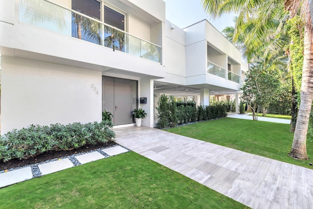 exterior space with a yard and stucco siding