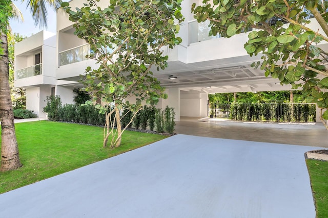 contemporary home with a front yard, concrete driveway, and stucco siding