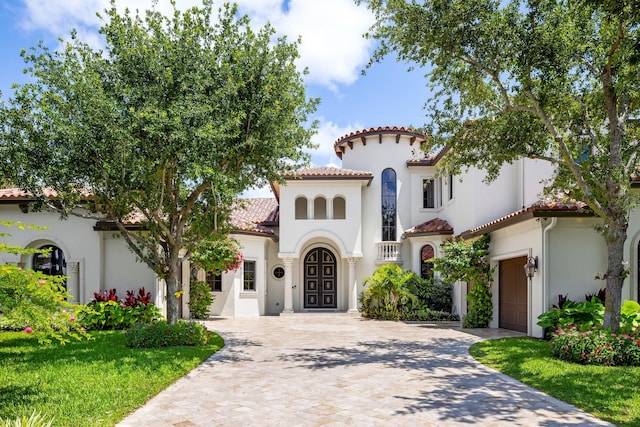 mediterranean / spanish house with a garage and a front yard