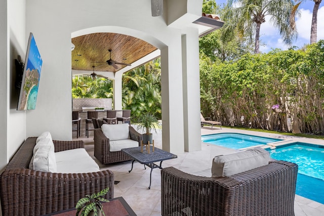 view of swimming pool featuring an outdoor living space, ceiling fan, a patio area, and an outdoor bar