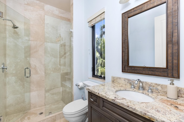 bathroom with plenty of natural light, large vanity, an enclosed shower, and toilet