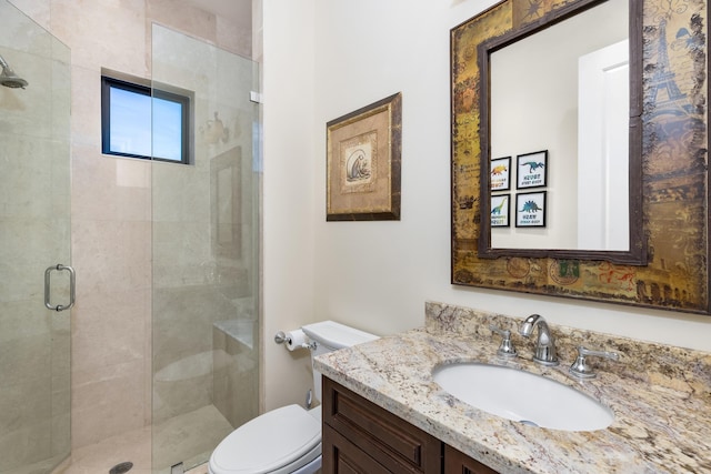 bathroom with walk in shower, vanity, and toilet