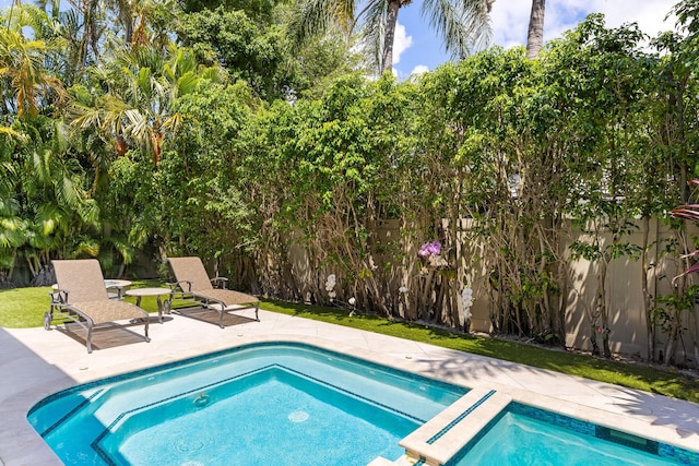 view of swimming pool featuring an in ground hot tub and a patio