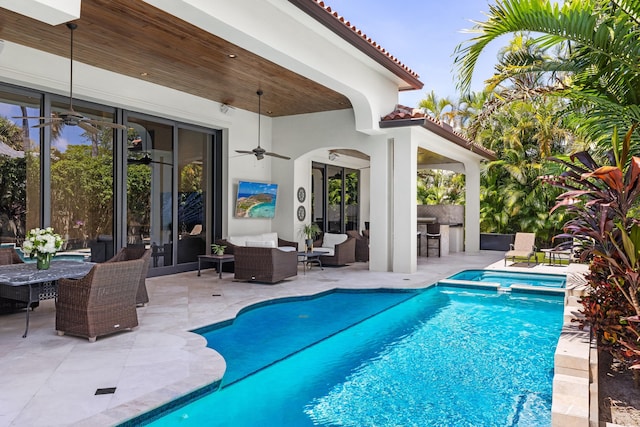 view of pool with outdoor lounge area, ceiling fan, exterior kitchen, and a patio