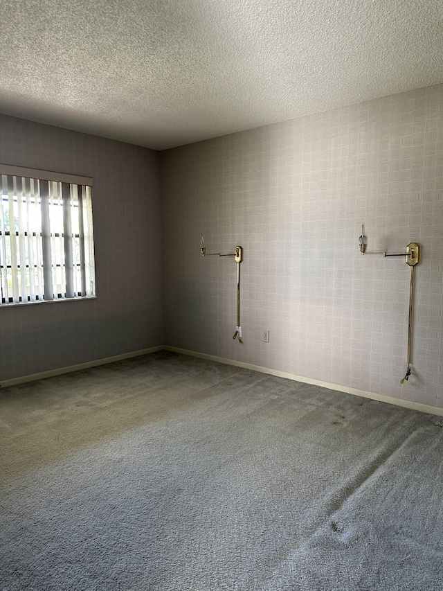 carpeted empty room featuring a textured ceiling