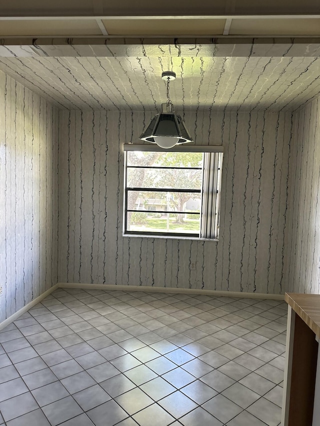 unfurnished room featuring light tile patterned floors and wooden walls