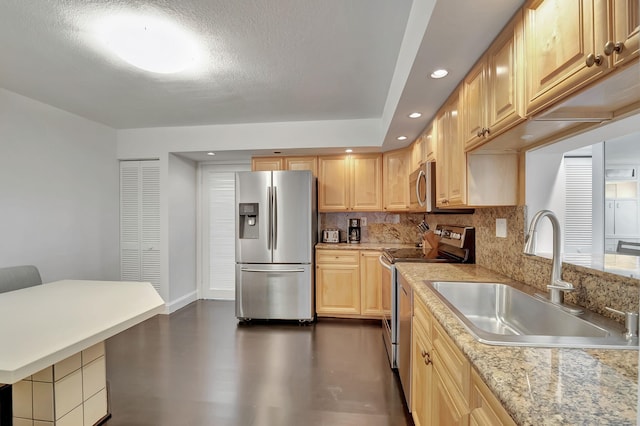 kitchen featuring light brown cabinetry, stainless steel appliances, and sink