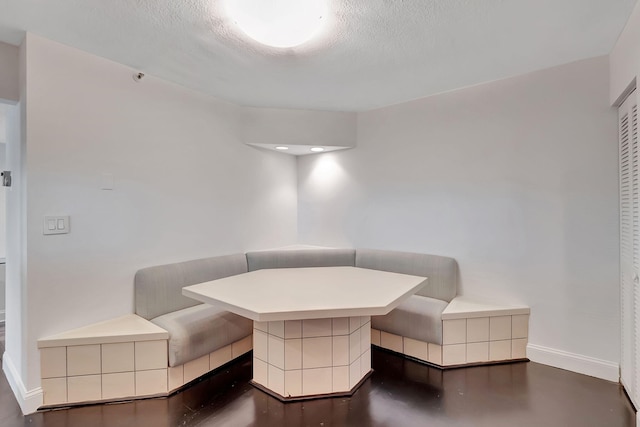 unfurnished dining area featuring breakfast area and a textured ceiling