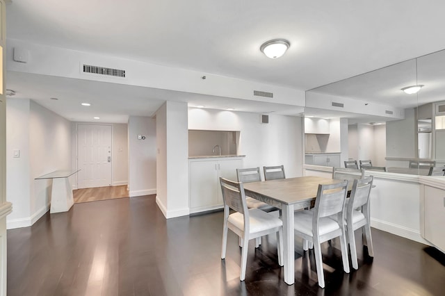 dining space with dark hardwood / wood-style floors and sink