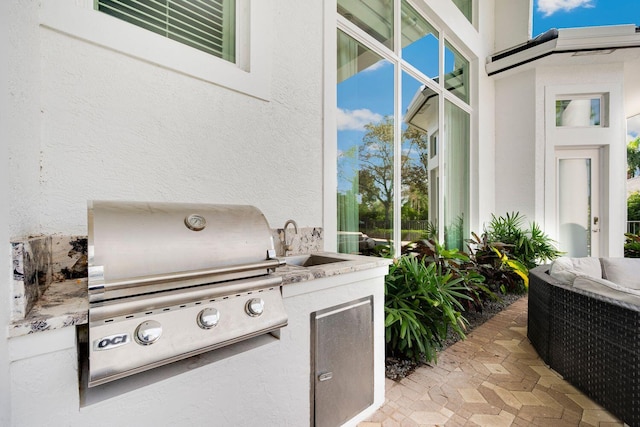 view of patio / terrace with area for grilling, an outdoor living space, and sink