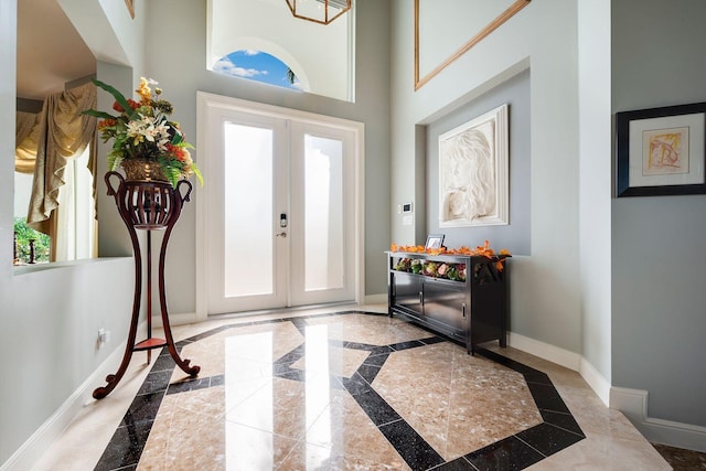 foyer entrance with a towering ceiling and french doors