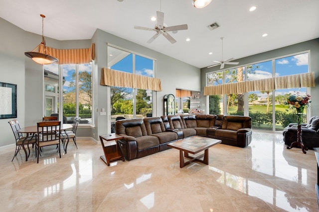 living room with ceiling fan and a high ceiling