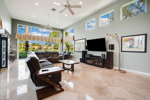 living room featuring ceiling fan and a high ceiling