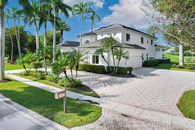 mediterranean / spanish-style home featuring a garage and a front yard